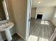 View from powder room into a well-lit living room with a fireplace and light gray wood floors at 1352 Creekside Nw Cir, Atlanta, GA 30318