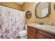 Cozy bathroom featuring a floral shower curtain, granite vanity, and decorative shelf at 138 Rutledge Rd, Temple, GA 30179