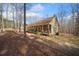 Serene view of a home with a covered porch surrounded by a wooded landscape at 138 Rutledge Rd, Temple, GA 30179