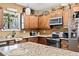 View of the kitchen featuring granite countertops, stainless steel appliances, and wooden cabinetry at 138 Rutledge Rd, Temple, GA 30179