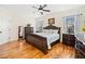 A main bedroom with a wooden bed frame, hardwood floors, and natural light from the two windows at 138 Rutledge Rd, Temple, GA 30179