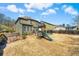 Large backyard featuring play structure, a wooden fence, and a covered patio area at 2145 Red Barn Ct, Cumming, GA 30040
