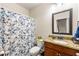 Well-lit bathroom with a granite countertop vanity and shower with a floral curtain at 2145 Red Barn Ct, Cumming, GA 30040