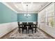 Elegant dining room with coffered ceiling, large window, and stylish table setting at 2145 Red Barn Ct, Cumming, GA 30040
