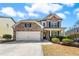 Charming two-story brick home featuring a two-car garage and well-manicured landscaping at 2145 Red Barn Ct, Cumming, GA 30040