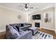 Cozy living room with a fireplace, ceiling fan, and comfortable gray sectional sofa at 2145 Red Barn Ct, Cumming, GA 30040