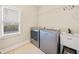 A laundry room with a front-loading washer and dryer and a large window at 3124 Bentgrass Ln, Kennesaw, GA 30144