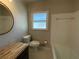 This bathroom has a tile surround, toilet, cabinet, wood countertop, and a window for light at 445 Royal Oaks Ter, Stone Mountain, GA 30087