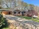 Inviting single story brick home showcasing an expansive driveway and lush front yard at 445 Royal Oaks Ter, Stone Mountain, GA 30087