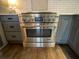 Close-up of stainless steel oven and stove with white tile backsplash and gray cabinetry at 445 Royal Oaks Ter, Stone Mountain, GA 30087