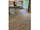View of hardwood floors leading to kitchen with island and dark cabinets, and large window at 445 Royal Oaks Ter, Stone Mountain, GA 30087