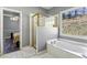 Bathroom featuring a bathtub, glass shower, and an exterior view through a window at 5163 Holly Springs Dr, Douglasville, GA 30135