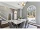 Bright dining room featuring a marble table, arched window, and elegant chandelier with views to the outside at 5163 Holly Springs Dr, Douglasville, GA 30135