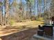 Expansive treelined backyard featuring mature trees, lawn, and outdoor seating area at 198 Lexington Ct, Riverdale, GA 30274
