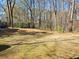 Spacious treelined backyard featuring mature trees, lawn, shed, and outdoor seating area at 198 Lexington Ct, Riverdale, GA 30274