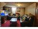 Cozy living room featuring dark leather couches, a red carpet, and a large flat screen television at 198 Lexington Ct, Riverdale, GA 30274