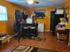 Unique orange room featuring bar with chairs, tile floor, TV, and small fridge at 198 Lexington Ct, Riverdale, GA 30274