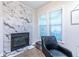 Cozy living room showcasing a modern fireplace with marble surround and a comfortable chair at 240 Renaissance Ne Pkwy # 106, Atlanta, GA 30308