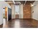 Spacious bedroom featuring exposed brick wall, wood floors, and bright window at 3235 Roswell Ne Rd # 421, Atlanta, GA 30305
