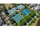 Aerial view featuring multiple well-maintained tennis courts surrounded by lush green trees, offering a recreational amenity at 5805 Clarion St., Cumming, GA 30040