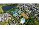Aerial view showcasing a community with tennis courts, a lake, a swimming pool, and picturesque homes surrounded by lush greenery at 5805 Clarion St., Cumming, GA 30040