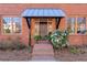 Inviting front entrance with a brick facade, covered porch, and manicured landscaping at 5805 Clarion St., Cumming, GA 30040