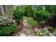 Picturesque backyard featuring a stone pathway, manicured landscaping, and lush greenery at 2698 Bonar Hall Path, Duluth, GA 30097