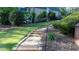 Stone pathway leading up to a two-story brick home and landscaped backyard with mature plantings and lawn at 2698 Bonar Hall Path, Duluth, GA 30097