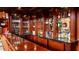 Basement wet bar boasts dark wood cabinetry, ample counter space, and illuminated shelving for spirits and glassware at 2698 Bonar Hall Path, Duluth, GA 30097