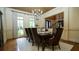 Elegant dining room with hardwood floors, chandelier, and seating for eight around a formal dining table at 2698 Bonar Hall Path, Duluth, GA 30097