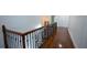 Hallway with rich hardwood floors and decorative railing, offering a view of the staircase at 2698 Bonar Hall Path, Duluth, GA 30097