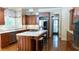 Open kitchen with stainless steel appliances, a center island with a cooktop, and ample cabinetry at 2698 Bonar Hall Path, Duluth, GA 30097