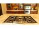 Close-up of a kitchen cooktop featuring stainless steel appliances, marble countertops, and custom wood cabinets at 2698 Bonar Hall Path, Duluth, GA 30097