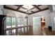 Bright living room with coffered ceilings, access to an outdoor deck, and abundant natural light through large windows at 2698 Bonar Hall Path, Duluth, GA 30097