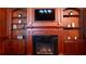 Classic fireplace design with dark stone, complemented by wooden built-in shelving on either side, plus media center at 2698 Bonar Hall Path, Duluth, GA 30097
