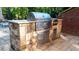 An outdoor kitchen features a stone surround, countertop, stainless steel grill, and convenient storage at 2698 Bonar Hall Path, Duluth, GA 30097