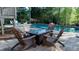 Outdoor seating with a fire pit beside the pool and lush landscaping, perfect for relaxing at 2698 Bonar Hall Path, Duluth, GA 30097