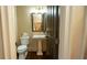 Charming powder room featuring a pedestal sink, dark wood door, and elegant lighting at 2698 Bonar Hall Path, Duluth, GA 30097