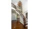 Elegant curved staircase with wrought iron railings, hardwood steps and floors, and decorative chandelier at 2698 Bonar Hall Path, Duluth, GA 30097