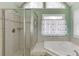 Clean bathroom featuring a walk-in shower, bathtub, and natural light to offer a bright and welcoming space at 1673 Chadwick Ridge Dr, Lawrenceville, GA 30043