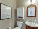 Well-lit bathroom with a vanity cabinet, white fixtures, and wall decor at 1673 Chadwick Ridge Dr, Lawrenceville, GA 30043