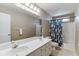 Bright bathroom features double sinks, white cabinetry, and a shower-tub combo at 1673 Chadwick Ridge Dr, Lawrenceville, GA 30043