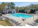 A large community pool with plenty of seating surrounded by a fence and trees at 1673 Chadwick Ridge Dr, Lawrenceville, GA 30043