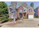 Beautiful brick home with mature trees, a bay window, and a two-car garage on a sunny day at 1673 Chadwick Ridge Dr, Lawrenceville, GA 30043