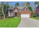 Charming two-story brick home with a well-manicured lawn, mature trees and a two car garage at 1673 Chadwick Ridge Dr, Lawrenceville, GA 30043