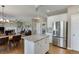 Open-concept kitchen boasts stainless steel appliances, granite island, and seamless flow to the adjacent dining area at 1673 Chadwick Ridge Dr, Lawrenceville, GA 30043