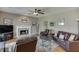 Comfortable living room featuring a fireplace, ceiling fan, and neutral color scheme at 1673 Chadwick Ridge Dr, Lawrenceville, GA 30043