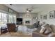 Cozy living room showcasing hardwood floors, a fireplace, and abundant natural light from large windows at 1673 Chadwick Ridge Dr, Lawrenceville, GA 30043