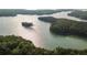 Expansive aerial view of a scenic lake with tree-covered islands, offering a tranquil and picturesque landscape at 540 Sawnee Village Blvd # D68, Cumming, GA 30040