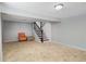 Spacious finished basement features tile flooring, a staircase, and an orange armchair at 6370 Boca Grande Blvd, Forest Park, GA 30297